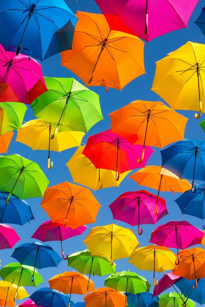 person taking photo of assorted-color umbrellas